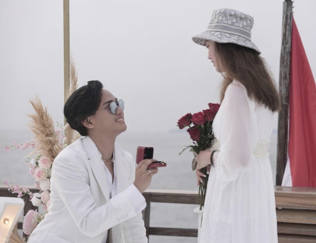 Selain kesuksesan kariernya, kisah cinta Indra Kenz pun jadi sorotan. Indra telah melamar sang pujaan hati yang bernama Vanessa Khong pada 14 Oktober 2021, tepat di hari ulang tahun yang ke-20 kekasihnya. Ia melamar Vanessa dengan disaksikan keluarga kedua belah pihak di atas kapal pesiar. Seluruh keluarga Indra dan Vanessa kompak mengenakan busana serba putih. Foto: Dok. Instagram @indrakenz.