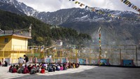 Anak-anak Tibet di pengasingan makan siang dengan latar pegunungan Dhauladhar Himalaya, di Dharmsala, India, Selasa, (8/2/2022). Aktifitas luar ruang yang ringan dan sederhana seperti ini bisa menjadi langkah awal untuk mencintai alam dan lingkungan. (AP Photo/Ashwini Bhatia)