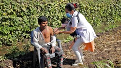 Seorang nakes melakukan vaksinasi ke pelosok India di tengah terik matahari sembari menggendong bayinya. Ini dilakukan demi sukses vaksinasi di India.