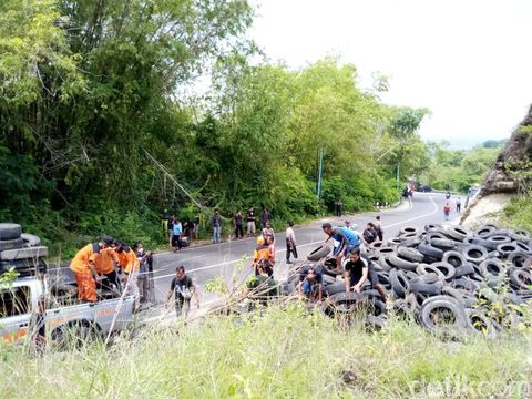 Relawan SAR dan komunitas trail memasang ban di tebing Bukit Bego, Selasa (8/2/2022).