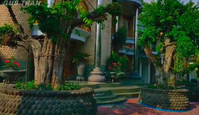 Berdiri di atas lahan 1,5 hektare, rumah ini memiliki banyak area hijau yang asri. Di depan rumah utama, terdapat empat pohon besar berbentuk bonsai. (Foto: YouTube/Gus Tran)