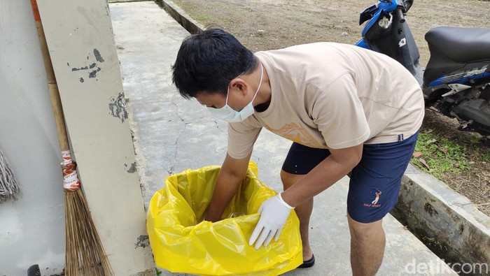Salah satu petugas tengah menyiapkan tempat sampah untuk pasien COVID-19 di Lebak
