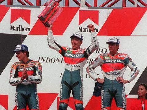 Tadayuki Okada from the Japanese Repsol Honda Team (C) raises his trophy on the podium with second place Mick Doohan from the Australian Repsol Honda team (R) and Alex Criville from the Spaninsh Repsol Honda team (L) at the World Championship Marlboro Indonesian Grand prix in Jakarta's Sentul circuit 28 September.  Okada won the 500 cc class race with a total time of 43'22.010 at 164.572 km/h.       AFP PHOTO (Photo by AFP)