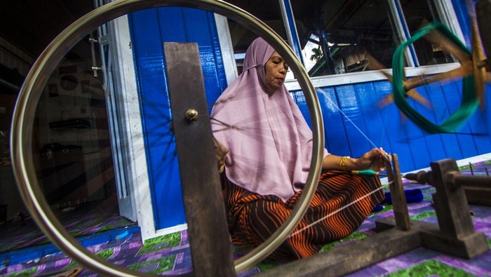 TENUN SARUNG KHAS SAMARINDA Perajin menyelesaikan pembuatan tenun sarung khas Samarinda di Kampung sentra Tenun Samarinda, Samarinda Seberang, Kalimantan Timur, Selasa (8/2/2022). Kain tenun tersebut merupakan salah satu kerajinan tangan khas Samarinda yang dijual seharga Rp250 ribu hingga Rp500 ribu tergantung motif pesanan. ANTARA FOTO/Bayu Pratama S/nym.