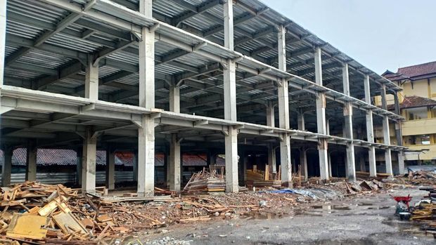 Warga mengantre di antara proyek pembangunan poliklinik RSUD dr Soekardjo yang terhenti akibat refokusing anggaran