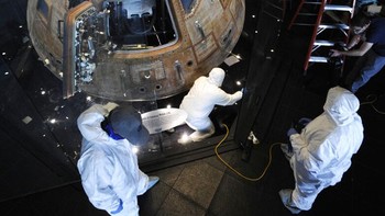 Para pekerja mengelilingi kapsul bulan Apollo 16 saat membersihkan wadahnya di Pusat Antariksa dan Roket AS di Huntsville.