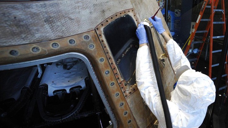 Workers open the glass case enclosing the Apollo 16 lunar capsule at the U.S. Space and Rocket Center in Huntsville, Ala., on Tuesday, Feb. 1, 2022. Following a break in routine maintenance because of the COVID-19 pandemic, the museum is sprucing up the antique spaceship before events marking the 50th anniversary of its flight to the moon in 1972. (AP Photo/Jay Reeves)