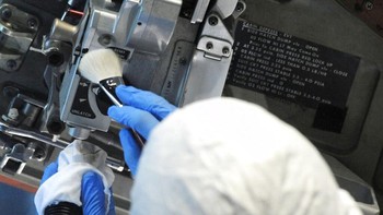 Seorang petugas menggunakan kuas dan penyedot debu untuk membersihkan palka pesawat luar angkasa Apollo 16 di Pusat Antariksa dan Roket AS di Huntsville.