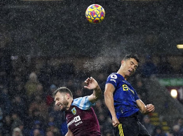 Manchester United's Cristiano Ronaldo, right, jumps for the ball with Burnley's Erik Pieters during the English Premier League soccer match between Burnley and Manchester United at Turf Moor, in Burnley, England, Tuesday, Feb. 8, 2022. (AP Photo/Jon Super)