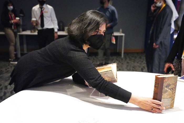 A mover pushes a box holding a Quran owned by U.S. President Thomas Jefferson as it leaves the American pavilion at Dubai Expo 2020 in Dubai, United Arab Emirates, Wednesday, Feb. 9, 2022. The Quran, on its first trip ever outside of the U.S. since being bought by Jefferson, had been on display at the Expo under constant guard. It was packed Wednesday to be returned to the Library of Congress. (AP Photo/Jon Gambrell)