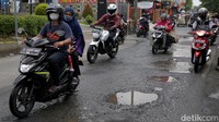 Sejumlah pengendara motor menghindari jalan yang berlubang di Jalan Bintara Raya, Kota Bekasi, Jawa Barat, Rabu (9/2/2022).