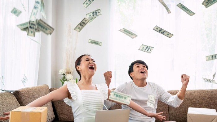 Happy couple success in their owner small business online with package box and money