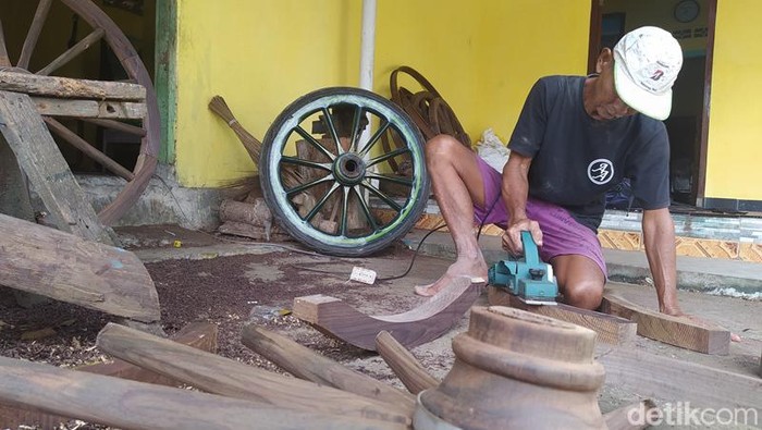 Manto saat mengerjakan pembuatan ban untuk andong di rumahnya.