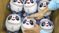 Seorang pekerja pabrik suvenir maskot Olimpiade Beijing 2022 mengemas boneka Bing Dwen Dwen ke dalam kardus. AP Photo.