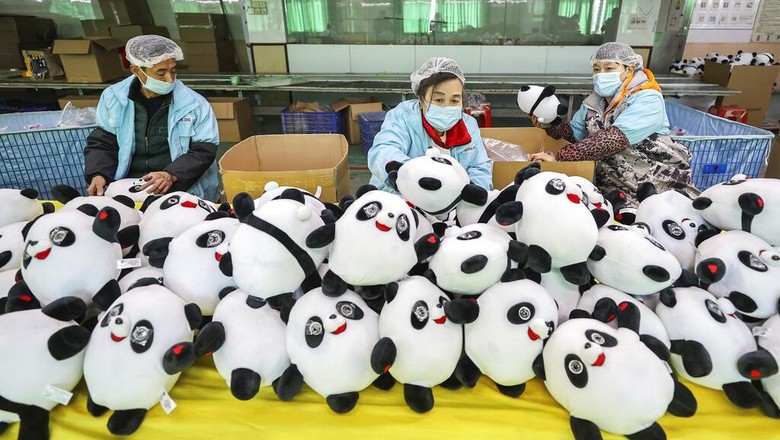 Workers at a factory manufacture Bing Dwen Dwen stuffed dolls, the mascot of 2022 Winter Olympics, in Jinjiang city in southeastern Chinas Fujian province Tuesday, Feb. 8, 2022. Long queues have formed for scarce 2022 Winter Olympic souvenirs, especially stuffed versions of Games mascot Bing Dwen Dwen, a panda in a winter coat. The Beijing Olympic organizing committee have asked souvenir factories to make more, the official Xinhua News Agency reported. Many reopened this week after shutting down for two weeks or more during the Lunar New Year holiday. (Chinatopix via AP)
