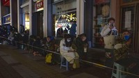 Orang-orang berbaris di sepanjang area pejalan kaki Wangfujing yang gelap di luar Gongmei Emporium untuk mengantre semalaman demi mendapatkan kesempatan membeli maskot Olimpiade Musim Dingin 2022 Bing Dwen Dwen di Beijing pada Selasa, (8/2/2022). Antrean panjang telah berlangsung dalam beberapa hari terakhir untuk dapatkan suvenir Olimpiade Musim Dingin 2022 yang langka, terutama versi boneka maskot Games Bing Dwen Dwen, seekor panda bermantel musim dingin. AP Photo/Ng Han Guan.