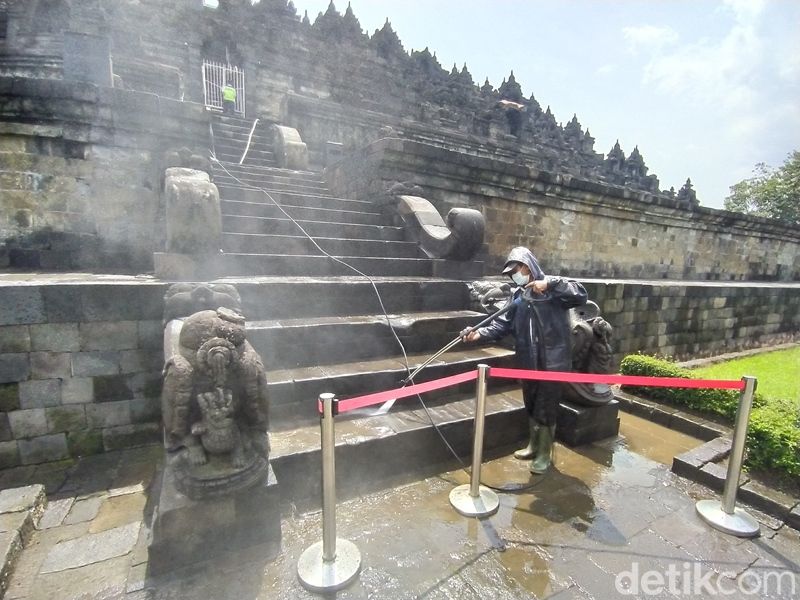Pegawai Balai Konservasi Borobudur (BKB) menyemprotkan air di bebatuan Candi Borobudur, Rabu (9/2/2022).