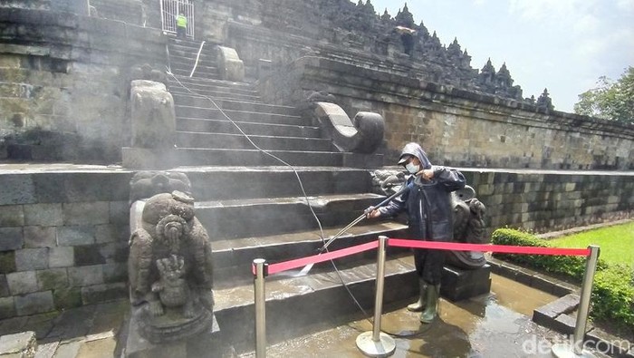 Pegawai Balai Konservasi Borobudur (BKB) menyemprotkan air di bebatuan Candi Borobudur, Rabu (9/2/2022).