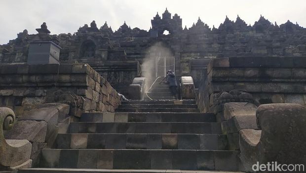Pegawai Balai Konservasi Borobudur (BKB) menyemprotkan air di bebatuan Candi Borobudur, Rabu (9/2/2022).