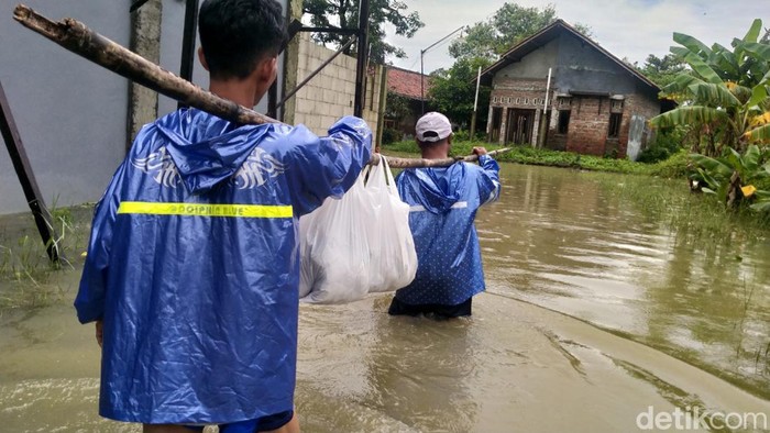 Perjuangan warga terobos banjir antar makanan korban banjir Pekalongan.