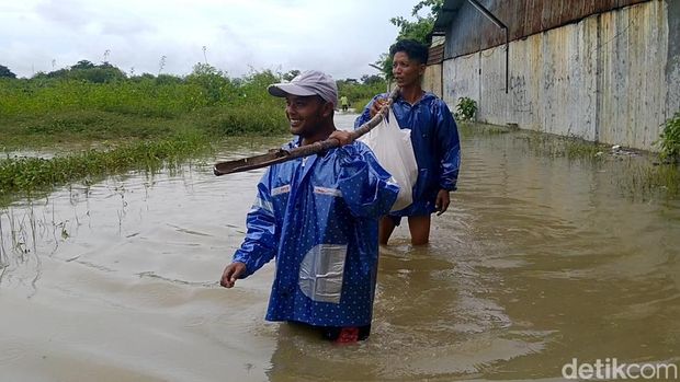 Perjuangan warga terobos banjir antar makanan korban banjir Pekalongan.