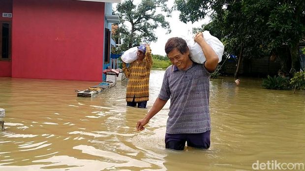 Perjuangan warga terobos banjir antar makanan korban banjir Pekalongan.
