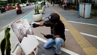 Seniman melukis tokoh pers Tirto Adhi Suwirjo di trotoar Jalan KH Wahid Hasyim Hasyim, Kabupaten Jombang, Jawa Timur, Rabu (9/2/2022). Melukis bareng Harmoni Kata dan Warna yang digelar Komunitas Pelukis (KOPI) bersama Persatuan Wartawan Indonesia tersebut untuk memperingati Hari Pers Nasional 2022. (ANTARA FOTO/Syaiful Arif).