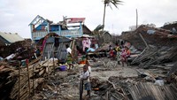 Sejumlah warga beraktivitas di dekat rumah mereka yang rusak hingga hancur akibat disapu Topan Batsirai di kawasan Mananjary, Madagaskar, Senin (7/2/2022).