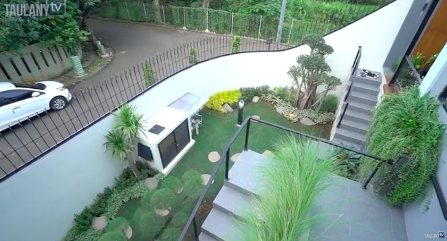 Taman bergaya minimalis Jepang menghiasi bagian depan rumah. Gue ngabisin banyak di taman, karena memang buat anak-anak main, kata mantan pembawa acara MTV Insomnia itu saat rumahnya didatangi Andre Taulany. (Foto: YouTube/Taulany TV)