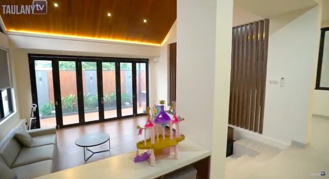 Di sinilah tempat Surya berkumpul bersama keluarganya sambil nonton TV. Pintu kaca yang berjejer memaksimalkan cahaya alami masuk ke rumah yang berdiri di atas lahan seluas 222 meter persegi. (Foto: YouTube/Taulany TV)