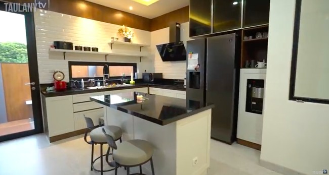 Dapur hadir dalam nuansa modern dengan palet monokrom. Terdapat meja island di tengah untuk memaksimalkan fungsi dapur. (Foto: YouTube/Taulany TV)