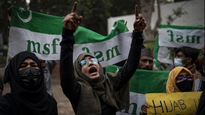 Indian Muslim students hold placards as they shout slogans during a protest against banning Muslim girls wearing hijab from attending classes at some schools in the southern Indian state of Karnataka, in New Delhi, India, Tuesday, Feb. 8, 2022. High school staff and authorities allege the girls are defying the uniform rules but students say they are being deprived of constitutionally guaranteed rights to practice their faith. (AP Photo/Altaf Qadri)