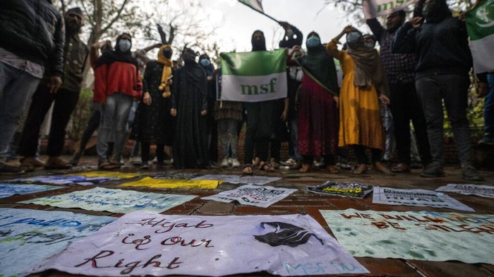 Indian Muslim students hold placards as they shout slogans during a protest against banning Muslim girls wearing hijab from attending classes at some schools in the southern Indian state of Karnataka, in New Delhi, India, Tuesday, Feb. 8, 2022. High school staff and authorities allege the girls are defying the uniform rules but students say they are being deprived of constitutionally guaranteed rights to practice their faith. (AP Photo/Altaf Qadri)