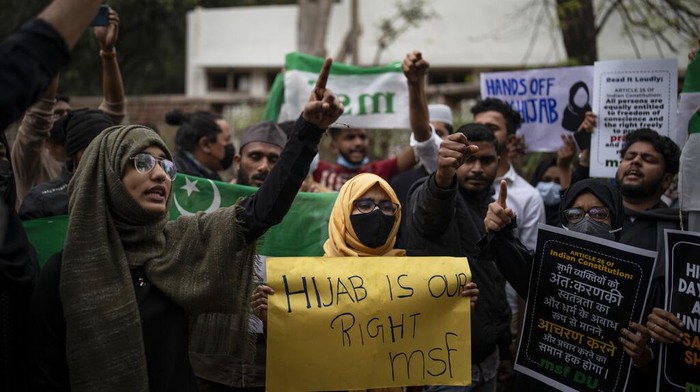 Indian Muslim students hold placards as they shout slogans during a protest against banning Muslim girls wearing hijab from attending classes at some schools in the southern Indian state of Karnataka, in New Delhi, India, Tuesday, Feb. 8, 2022. High school staff and authorities allege the girls are defying the uniform rules but students say they are being deprived of constitutionally guaranteed rights to practice their faith. (AP Photo/Altaf Qadri)