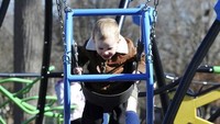 Seorang ibu bermain bersama anaknya di taman kota Owensboro, Kentucky, AS, Selasa (8/2/2022). Mengajak bermain interaktif tanpa gawai membantu proses komunikasi dan ikatan emosional yang humanis. (Alan Warren/The Messenger-Inquirer via AP)