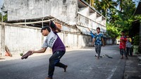 Anak-anak bermain kasti menggunakan pemukul dari sandal, di sebuah gang di Narathiwat, Thailand, 5 Februari 2022. Permainan dunia nyata ini nyaris tergerus kebahagiaan virtual lewat permainan gawai. (Photo by Matt Hunt / SOPA Images/Sipa USA)No Use Germany.