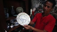 Pemilik menunjukan barang antik dagangannya piring makan dari tahun 1400 an di Tangerang Selatan, Banten, Rabu (9/2/2022).