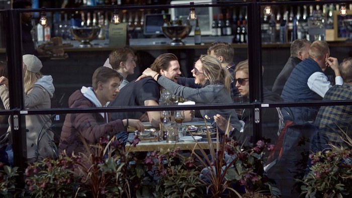 Bye COVID-19! 5 Negara Ini Sudah Tak Wajibkan Masker FILE - In this Saturday, April 4, 2020 file photo, a couple hug and laugh as they have lunch in a restaurant in Stockholm, Sweden. Sweden’s response to the spread of coronavirus was too slow and its preparations to handle a pandemic were insufficient, a stinging official report concluded Friday Oct. 29, 2021. The Scandinavian country has stood out among European nations for its comparatively hands-off response to the pandemic, emphasizing individual responsibility and choices instead of mandated government health measures. (AP Photo/Andres Kudacki, File)