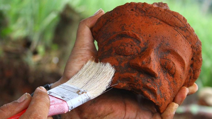 Anggota tim Balai Pelestarian Cagar Budaya (BPCB) Trowulan membersihkan potongan relief yang ditemukan saat eskavasi situs Srigading di Lawang, Malang, Jawa Timur, Kamis (10/2/2022). Situs tersebut diduga adalah sebuah candi peninggalan kerajaan Medang pada tahun 929 Masehi di era pemerintahan Mpu Sindok karena dari penggalian ditemukan Yoni, potongan relief serta struktur bangunan kuno. ANTARA FOTO/Ari Bowo Sucipto/nz