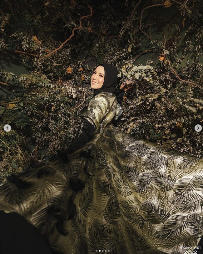 Stylist @meizy_latuconsina yang ikut berperan dalam sesi foto Tya Ariestya ini mengatakan nuansa glamour motif daun perpaduan hijau dan hitam menjadi pilihan untuk mengabadikan penampilan sang artis berhijab. Foto: Dok. Instagram @tya_ariestya.