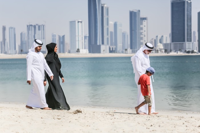 Arab family walking on the autumn beach