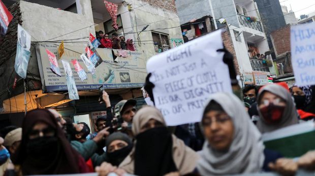 Residents watch as Muslim women take part in a protest organised by All India Majlis-e-Ittehadul Muslimeen (AIMM) against the recent hijab ban in few colleges of Karnataka state, at Shaheen Bagh in New Delhi, India, February 9, 2022. REUTERS/Anushree Fadnavis