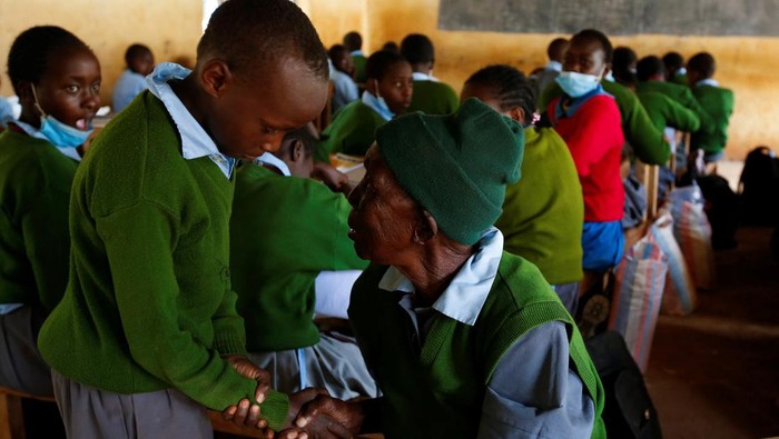 Kejar Impian Jadi Dokter, Nenek 98 Tahun Ini Masuk SD Lagi Priscilla Sitienei, a 98-year-old primary school student in grade six, is helped to adjust her school uniform by her class-teacher Leonida Taalam at the Leaders Vision Preparatory School in Ndalat village of Nandi County, Kenya, January 25, 2022. REUTERS/Monicah Mwangi