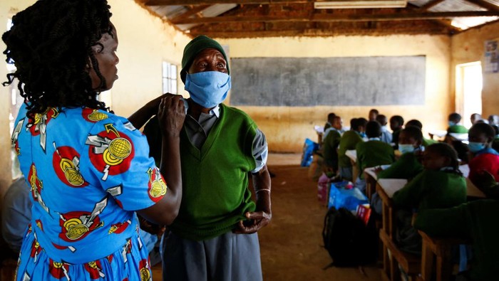 Kejar Impian Jadi Dokter, Nenek 98 Tahun Ini Masuk SD Lagi Priscilla Sitienei, a 98-year-old primary school student in grade six, is helped to adjust her school uniform by her class-teacher Leonida Taalam at the Leaders Vision Preparatory School in Ndalat village of Nandi County, Kenya, January 25, 2022. REUTERS/Monicah Mwangi