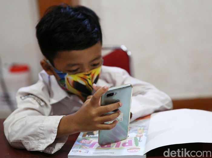 Siswa siswi menggunakan fasilitas WiFi gratis saat mengikuti kegiatan pembelajaran jarak jauh di balai warga RW 05 Kelurahan Kuningan Barat, Mampang Prapatan, Jakarta, Jumat (27/8/2020). WiFi gratis ini disediakan oleh swadaya warga RW 05 guna membantu anak-anak yang melakukan pembelajaran jarak jauh yang terkendala dengan kuota internet.
