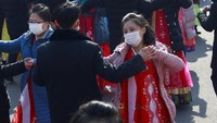 Para pelajar menari dengan mengenakan jaket tebal di musim dingin di bulan Februari, untuk merayakan ulang tahun ke-74 berdirinya angkatan bersenjata Korea Utara, di halaman Pyongyang Indoor Stadium, Pyongyang, Selasa (8/2/2022). (AP Photo/Jon Chol Jin)