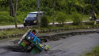 Pengendara motor terjatuh saat melintas di Jalan Nasional Ahmad Yani yang longsor di Kabupaten Balangan, Kalimantan Selatan, Jumat (11/2/2022).