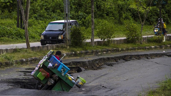 JALAN NASIONAL DI KALIMANTAN SELATAN LONGSOR Pengendara motor melintas di Jalan Nasional Ahmad Yani yang longsor di Kabupaten Balangan, Kalimantan Selatan, Jumat (11/2/2022). Jalan Nasional penghubung antar Provinsi Kalimantan Selatan-Kalimantan Timur tersebut mengalami longsor sejak satu tahun lalu hingga kini belum diperbaiki sehingga dapat membahayakan warga yang melintas di jalan tersebut. ANTARA FOTO/Bayu Pratama S/YU