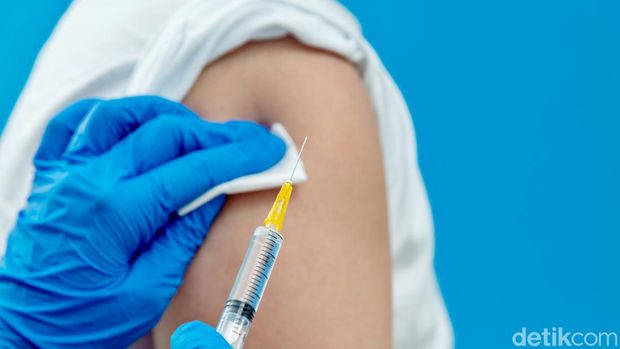 Doctor vaccinating for a boy on blue background.