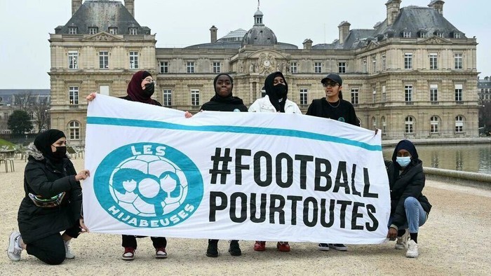 Muslim footballers protest in front of the French Senate with a banner reading 